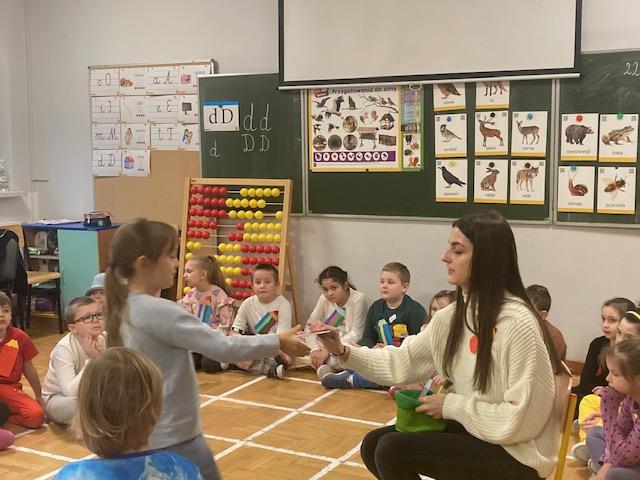 nauczyciel rozdaje zakładki do książki