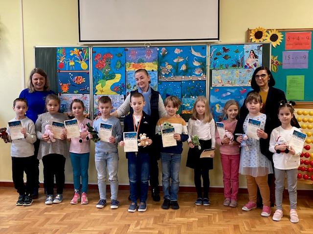 dzieci pozują do zdjęć z dyplomami