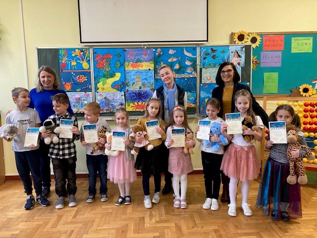 dzieci pozują do zdjęć z dyplomami
