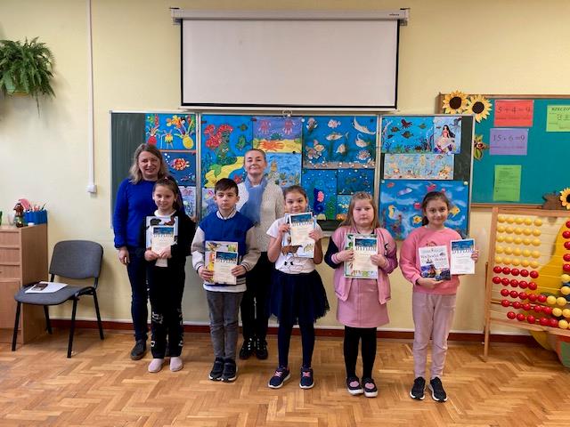 dzieci pozują do zdjęć z dyplomami