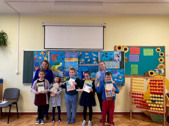 dzieci pozują do zdjęć z dyplomami