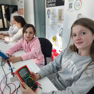 Uśmiechnięte uczennice po wykonanym zadaniu w pracowni fizycznej