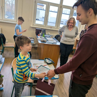 Przewodniczący szkoły składa podziękowanie uczniowi klasy 3a za wykonanie kartek świątecznych