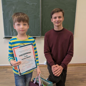 Przewodniczący szkoły składa podziękowanie uczniowi klasy 3a za wykonanie kartek świątecznych