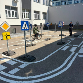 dziecko jedzie na rowerze pod nadzorem policjanta