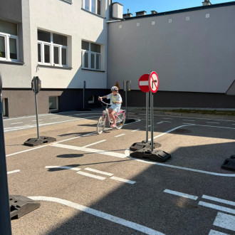 dziecko jedzie na rowerze pod nadzorem policjanta