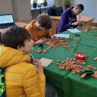 Uczniowie klasy 8 próbują wykonać zadanie z klockami