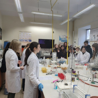 Uczniowie w laboratorium chemicznym, obserwują zachodzące reakcje