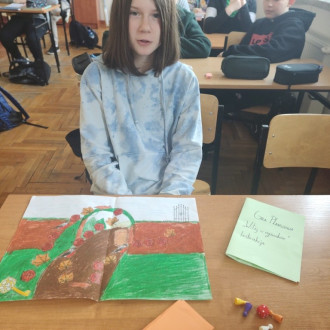 Uczennica prezentująca wykonaną przez siebie grę planszową