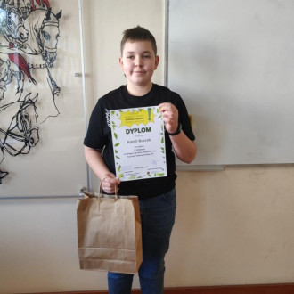 Uczeń klasy piątej z dyplomem i nagrodą