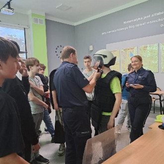 Uczniowie klasy ósmej zapoznają się z elementami stroju policjanta