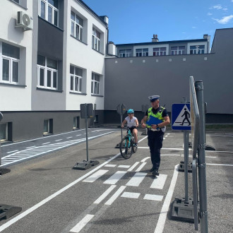 dziewczynka jedzie na rowerze po placu manewrowym