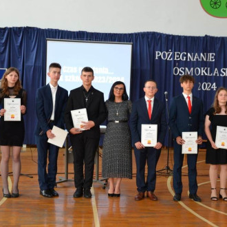 Uczniowie z dyplomani za pokonywanie swoich trudności, obok uśmiechnięta pani Dyrektor