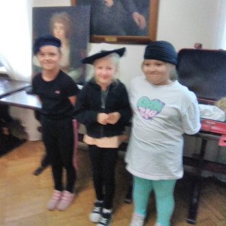 trzy dziewczynki pozują do zdjęcia w nakryciach głowy