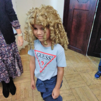 chłopiec pozuje w peruce