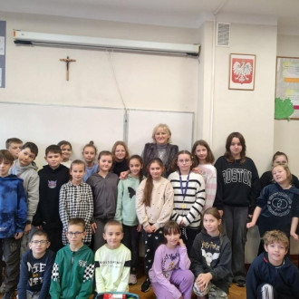 Uśmiechnięci uczniowie klasy czwartej wraz z panią wicedyrektor